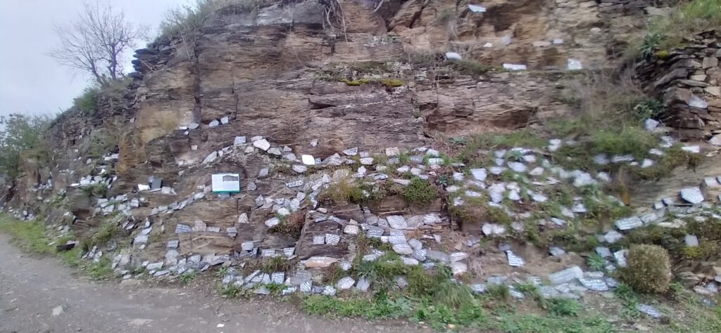 Steintafeln an einer Felswand.